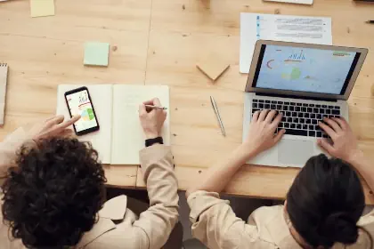 An overhead view of a business analyst and a software engineer, developing together on a web-based application